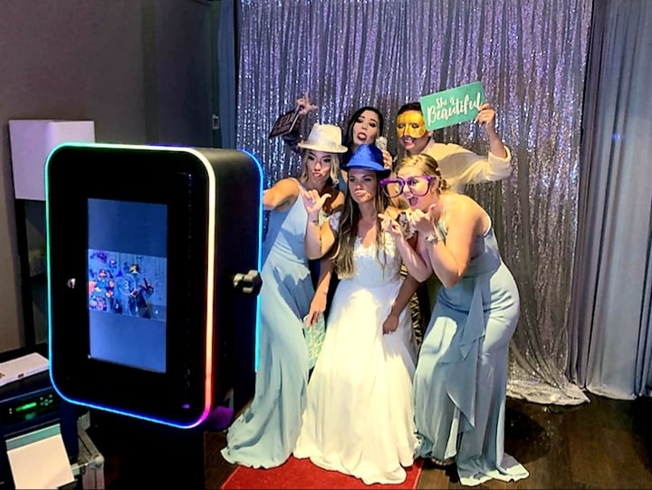 The photobooth Ruth the Booth with happy wedding guests after using Juniper Blue Daytona Beach wedding planners